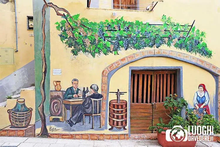 Uomini bevono del vino nella cantina del paese